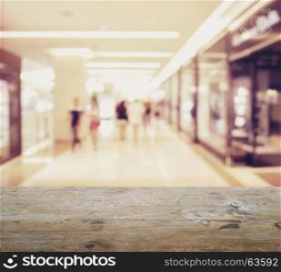 wooden table top with blur of department store with bokeh background.