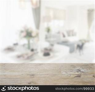 wooden table top with blur of dining table continue to living area