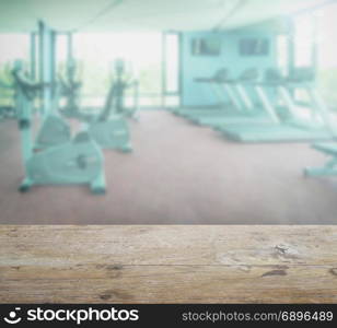 wooden table top with blur of fitness room interior background