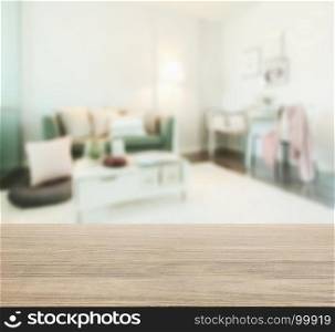 wooden table top with blur of living room in modern interior style