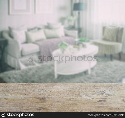 wooden table top with blur of living room interior with set of elegant teacup