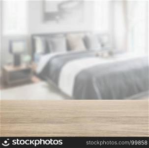 wooden table top with blur of modern bedroom in black and white color tone