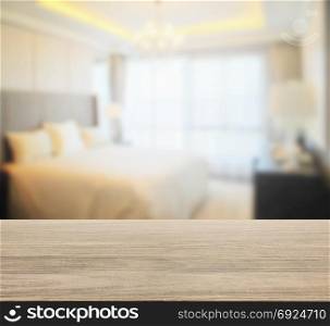 wooden table top with blur of modern bedroom interior