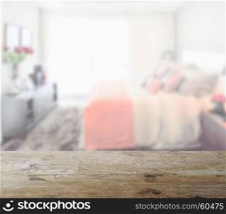 wooden table top with blur of modern bedroom interior as background