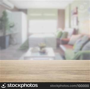 wooden table top with blur of modern bedroom with colorful decoration