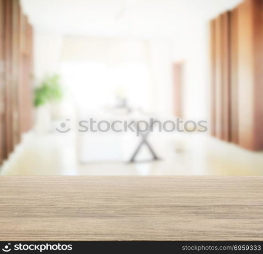 wooden table top with blur of modern dining room interior.