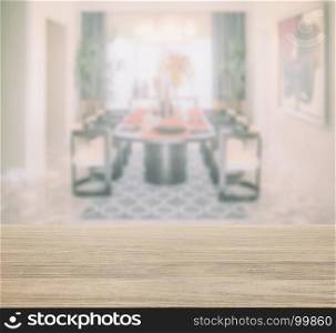 wooden table top with blur of modern dining table in dining room
