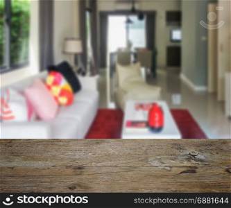 wooden table top with blur of modern living room and dining table at home