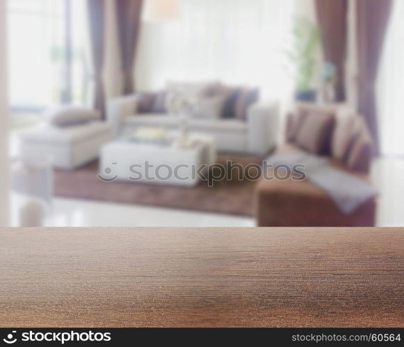 wooden table top with blur of modern living room interior as background