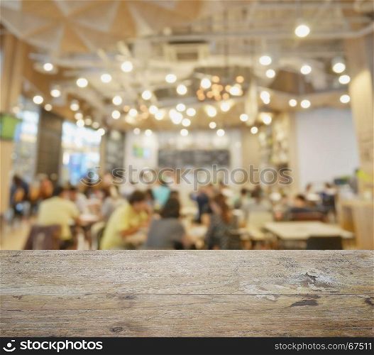 wooden table top with blur of restaurant and cafe as background