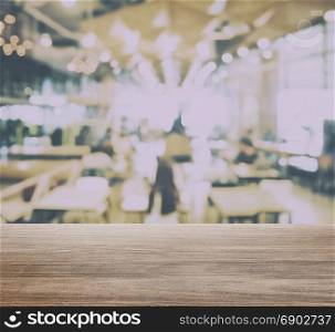 wooden table top with blur of restaurant interior with lot of bokeh as background
