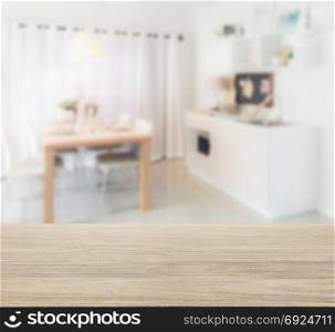 wooden table top with blur of wooden dining table next to pantry in modern kitchen