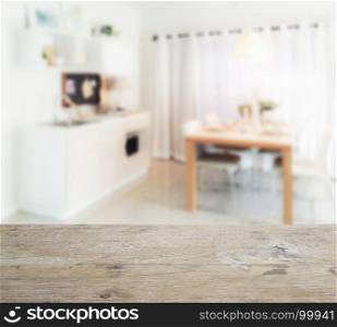 wooden table top with blur of wooden dining table next to pantry in modern kitchen