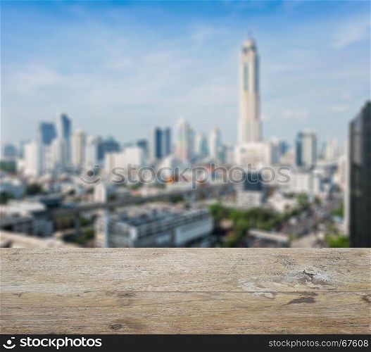 wooden table top with blurred abstract background of bangkok downtown cityscape