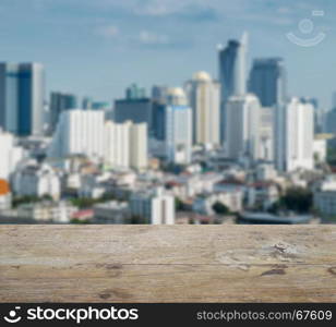 wooden table top with blurred abstract background of bangkok downtown cityscape