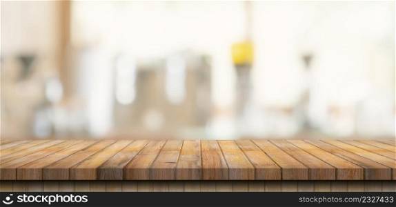 Wooden table top with blurred people in coffee shop and cafe background for display montage, copy space.