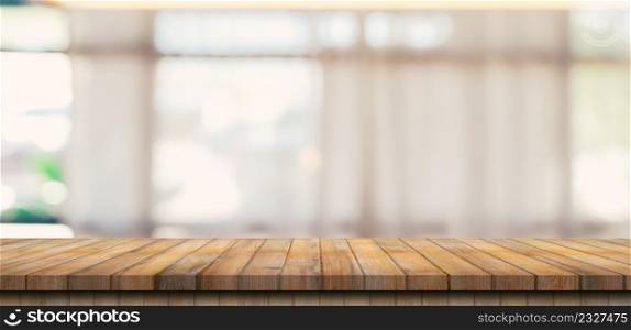 Wooden table top with blurred people in coffee shop and cafe background for display montage, copy space.