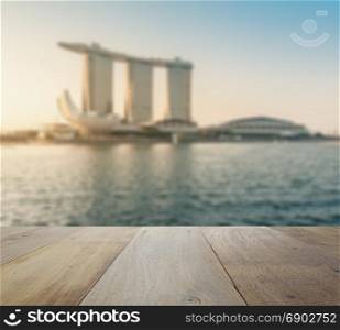 wooden table top with blurred skyline of singapore cityscape as background