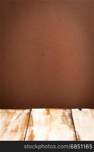 Wooden table top with brown wall background