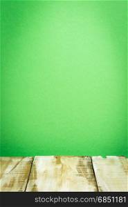 Wooden table top with green wall background