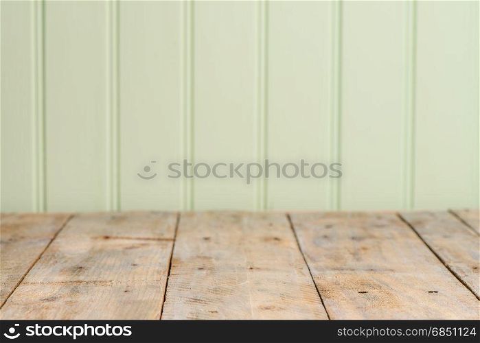 Wooden table top with green wood wall background