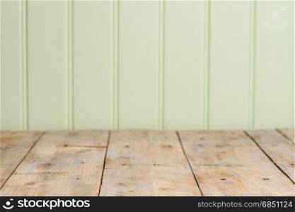 Wooden table top with green wood wall background