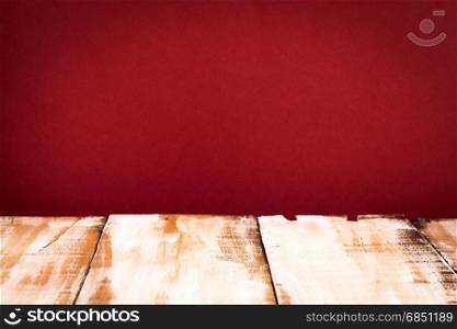 Wooden table top with red wall background