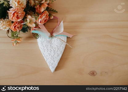 wooden table with a bouquet of flowers and a white heart