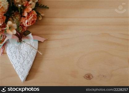 wooden table with a bouquet of flowers and a white heart