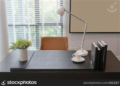 wooden table with lamp and books in modern working room interior