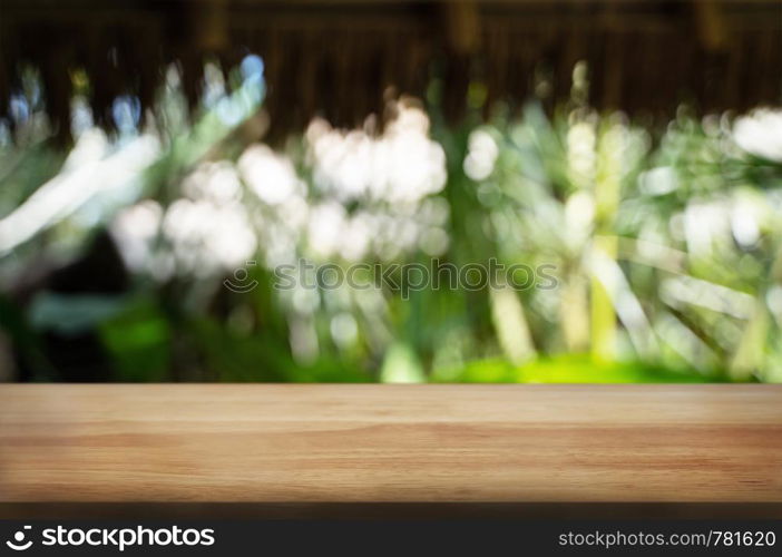Wooden tabletop in front of blurred green nature background.