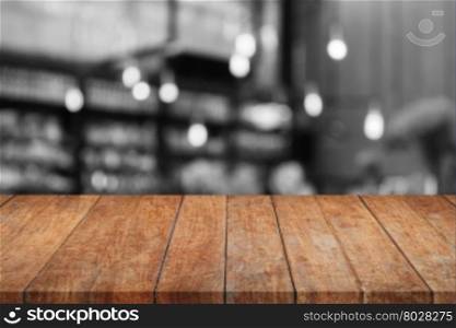 Wooden tabletop with black and white coffee shop blurred background, stock photo