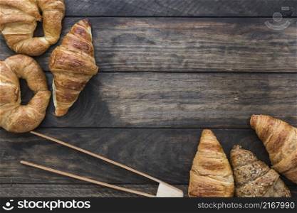 wooden tongs near croissants