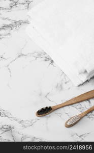 wooden toothbrush white towels marble surface