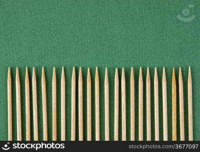 wooden toothpicks in paling shape on the green background