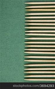 wooden toothpicks in paling shape on the green background