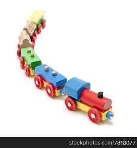 Wooden toy train with a locomotive and five carriages with a subtle reflection on a white background and a shallow depth of field
