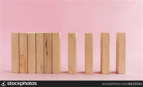Wooden toys arranged in a horizontal row on pink background for leisure activities concept