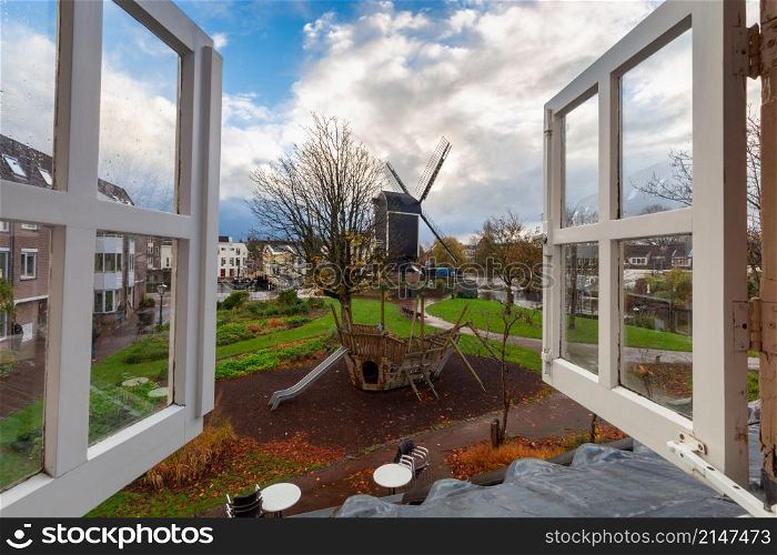Wooden traditional Dutch windmill. Leiden Netherlands. An old wooden mill on the banks of a canal in Leiden.