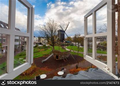 Wooden traditional Dutch windmill. Leiden Netherlands. An old wooden mill on the banks of a canal in Leiden.
