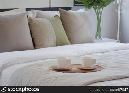 wooden tray of tea set on bed in modern bedroom interior