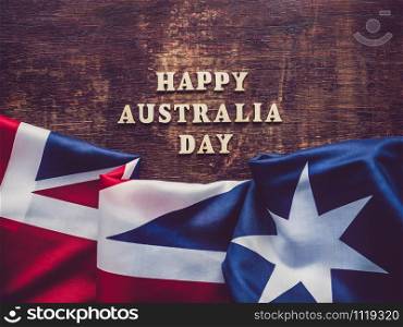 Wooden unpainted letters of the alphabet on a dark background. Australia Day. Beautiful, bright card. Top view, close-up. National holiday concept. Australia Day. Beautiful, bright card. Top view