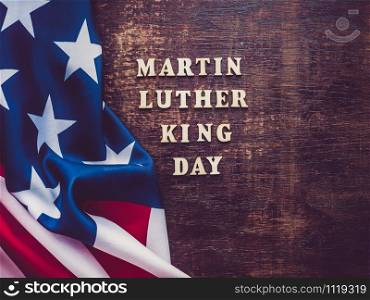 Wooden unpainted letters of the alphabet on a dark background. Martin Luther King Jr. Day. Top view, close-up. National holiday concept. Martin Luther King Jr. Beautiful, bright card