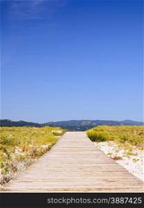 Wooden walkway to the beach one summer day with blue sky
