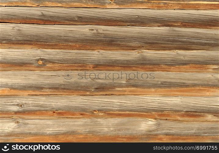 Wooden wall of natural brown logs, background texture