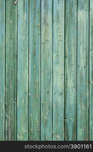 wooden wall of shed consisiting of blue green planks with faiding paint