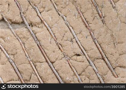 Wooden wall, plastered brown clay with a battens of thin twigs
