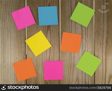 wooden wall with papers in green yellow blue pink and orange