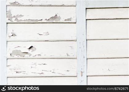 wooden wall with peeling white paint.