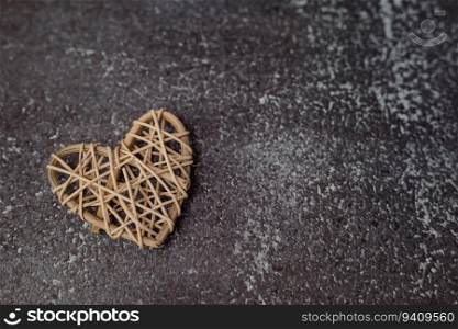 Wooden wicker heart on grunge background with copy space for love and Valentine’s day concept